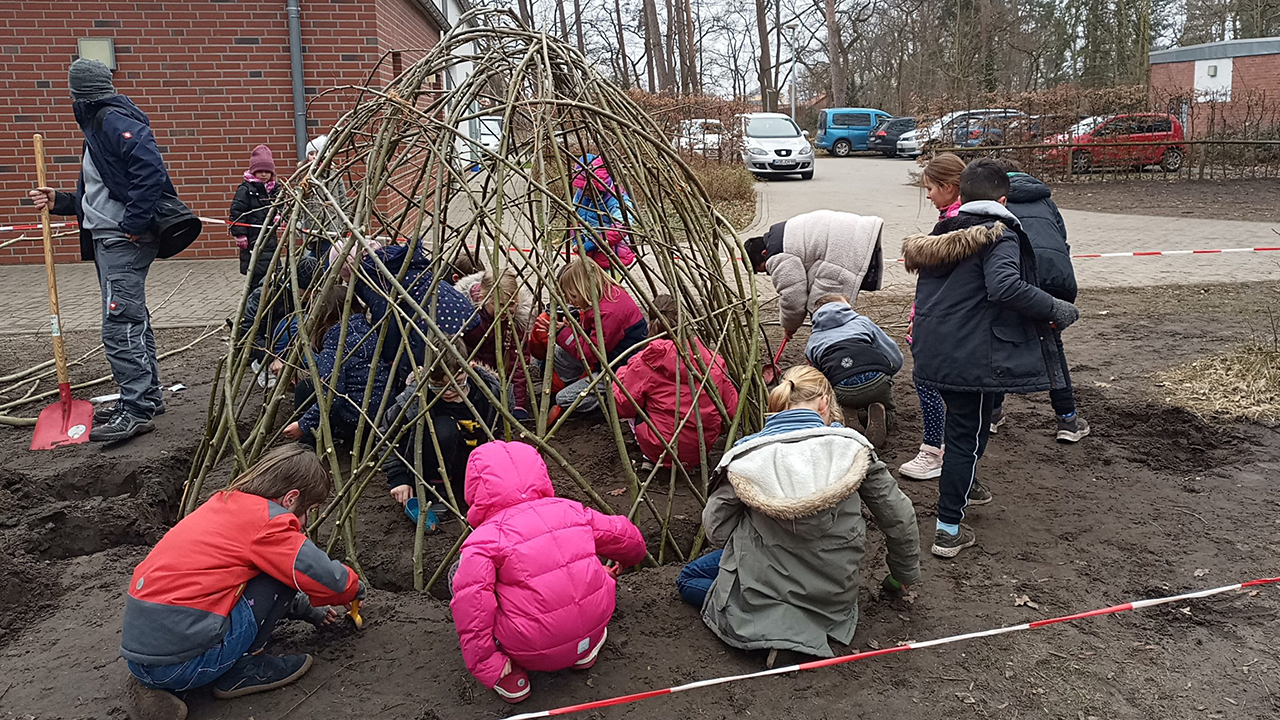 Kinder helfen beim Bau des neuen Weidentipis